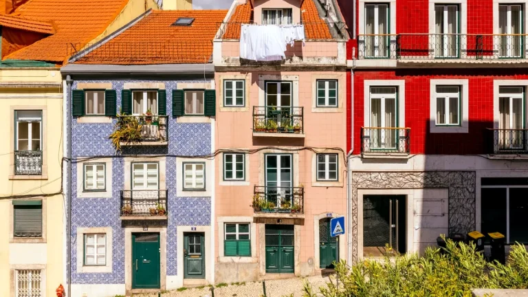 Façades d'immeubles résidentiels portugais aux couleurs variées, avec fenêtres, balcons et azulejos.